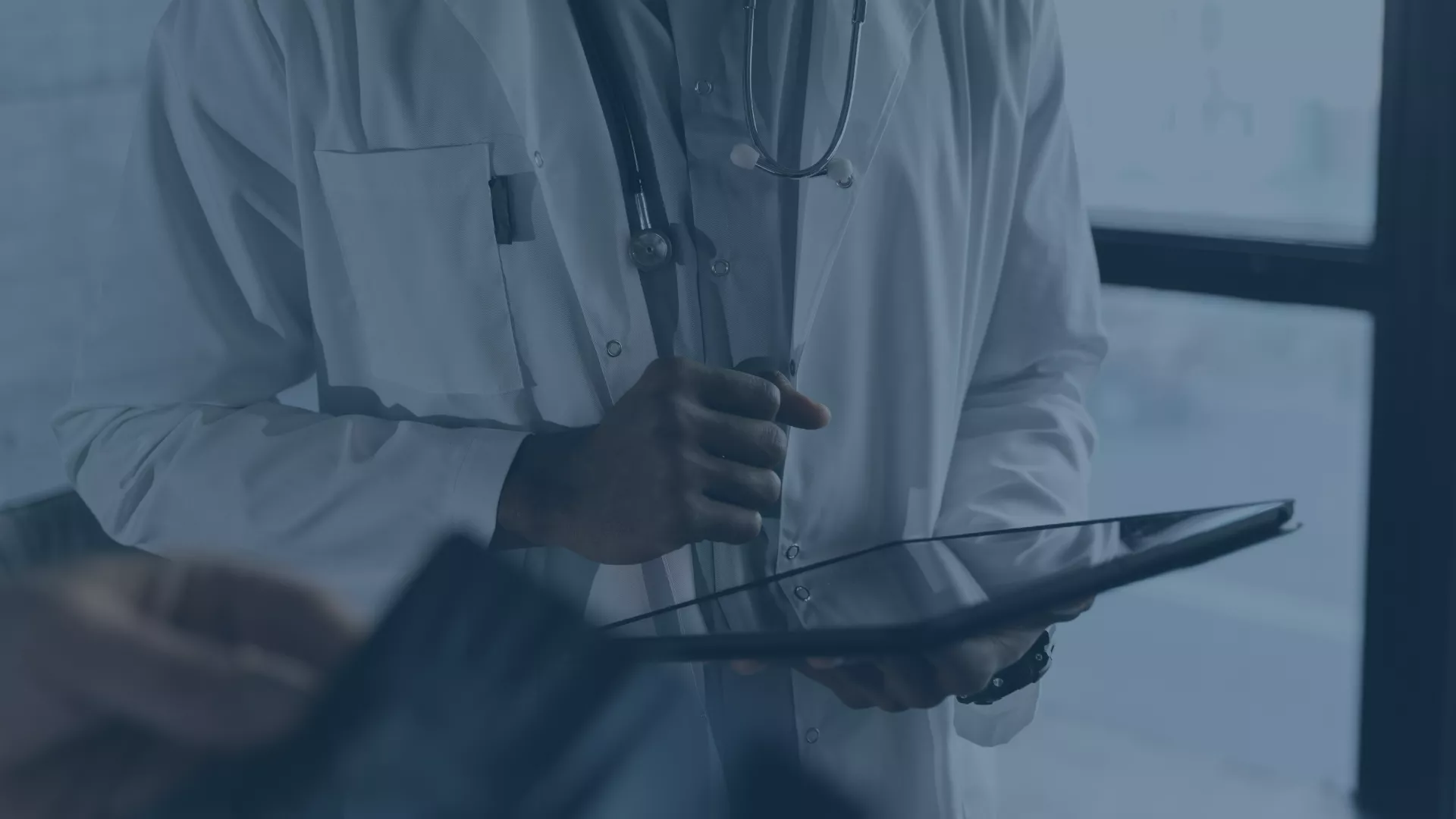 Ein Arzt im weißen Kittel hält ein Tablet in der Hand – Symbolbild für den digitalen Wandel im Gesundheitswesen. Die Elisabeth-Klinik Bigge setzt im Rahmen eines Mobile Device Management-Projekts gemeinsam mit audius auf moderne Technologien wie Jamf Pro und den Apple Business Manager zur zentralen Verwaltung mobiler Endgeräte.