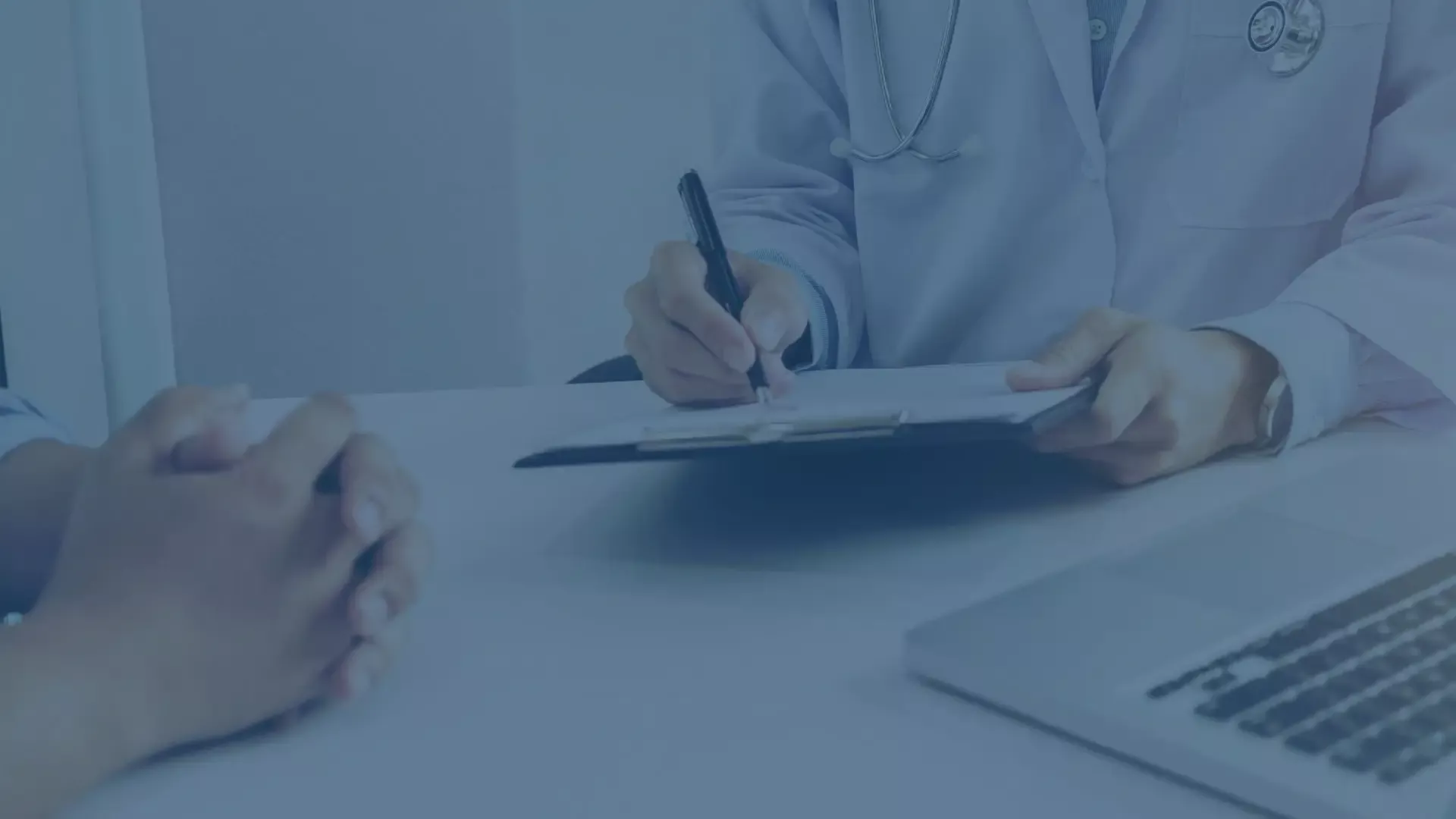 Arzt im Gespräch mit Patient, macht handschriftliche Notizen auf einer Akte, symbolisiert die Digitalisierung und Einführung von MDM-Lösungen in der Klinik.