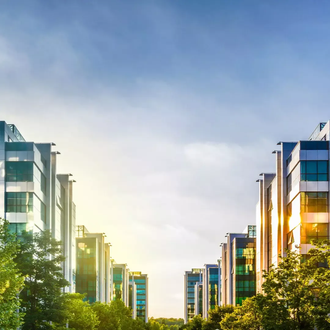 Reihe moderner Bürogebäude bei Sonnenlicht, symbolisiert einen erfolgreichen Business-Standort oder eine Kundenstimme aus dem Immobiliensektor