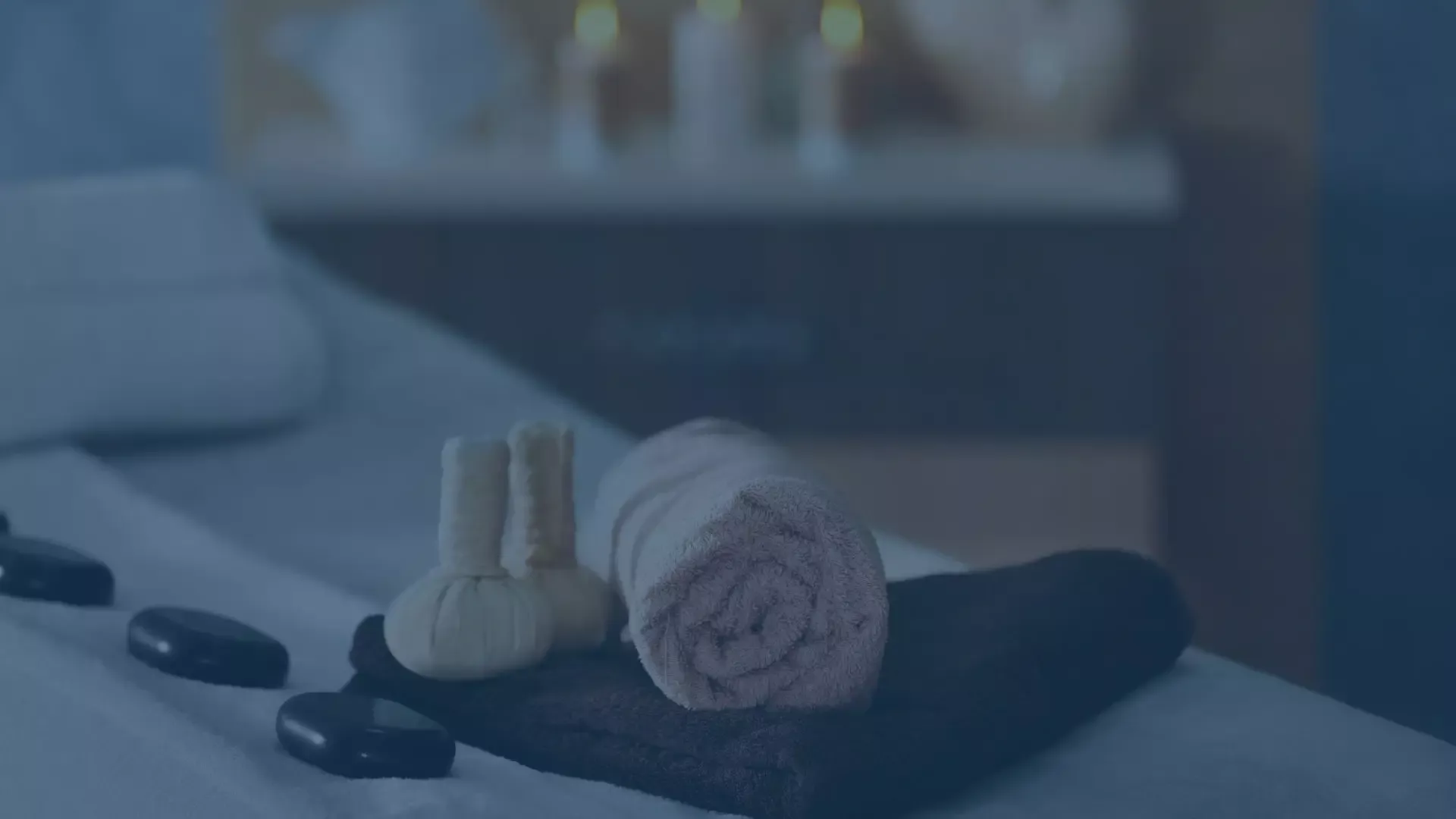 Wellnessbereich mit Massagesteinen und Handtüchern auf einer Liege, symbolisiert einen MDM Use Case für Mobile Device Management in der Wellnessbranche